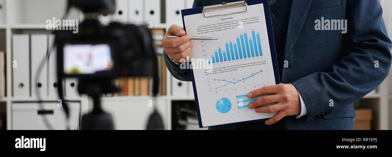 Male in suit and tie show stats graph pad Stock Photo Alamy