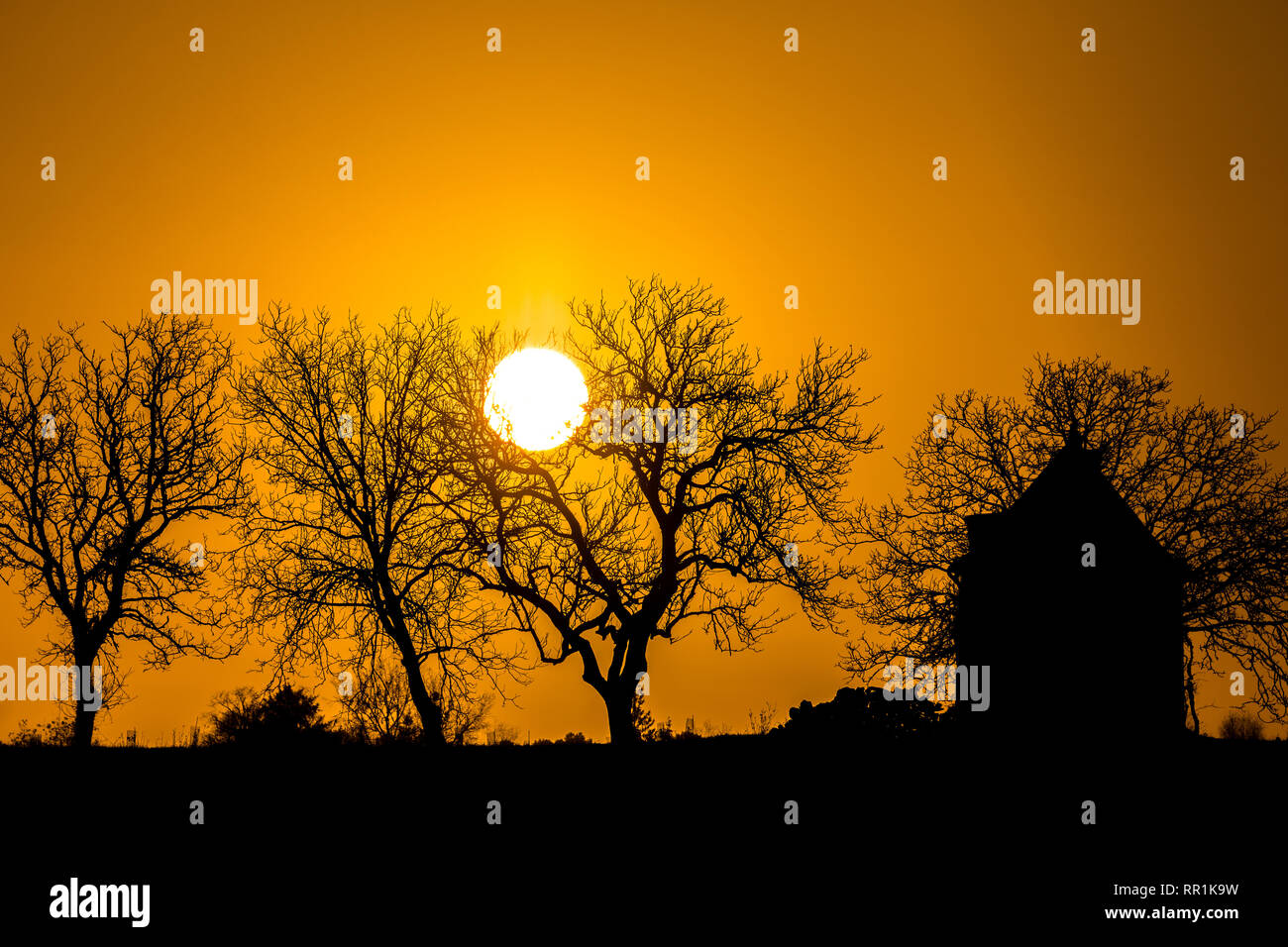 Sunrise and silhouette of tiny house, France. Stock Photo