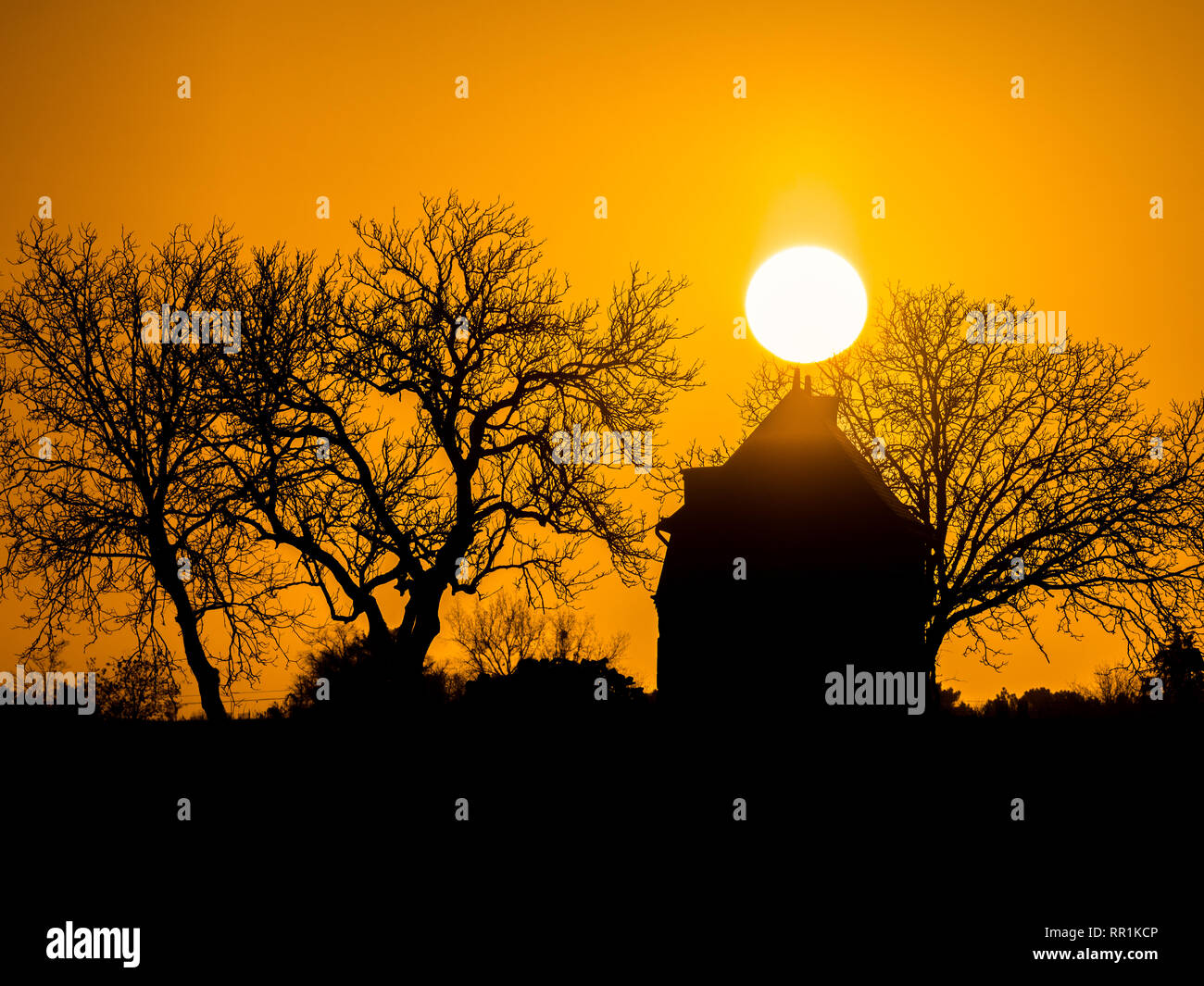 Sunrise and silhouette of tiny house, France. Stock Photo