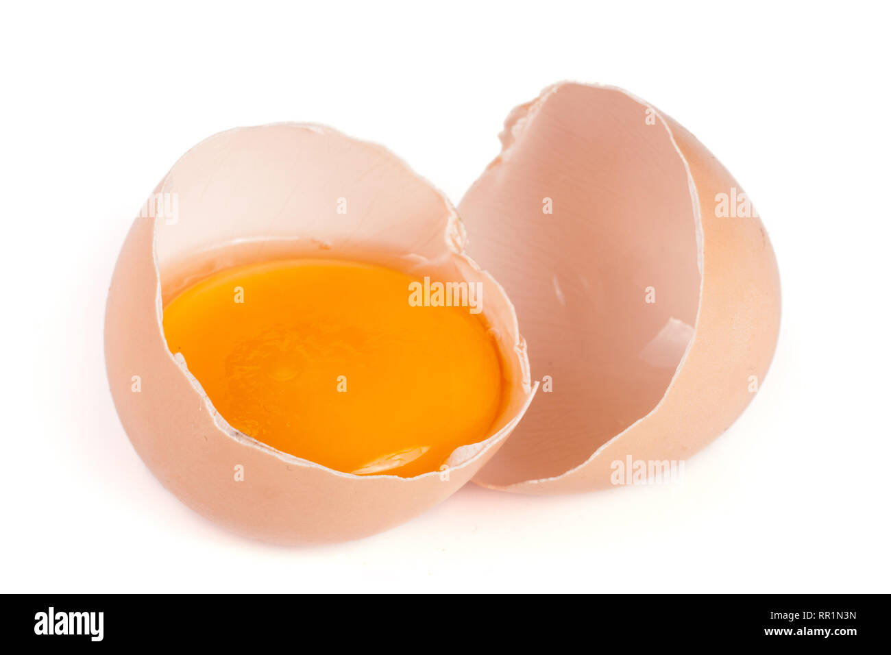 Broken egg with yolk and eggshell isolated on white background Stock