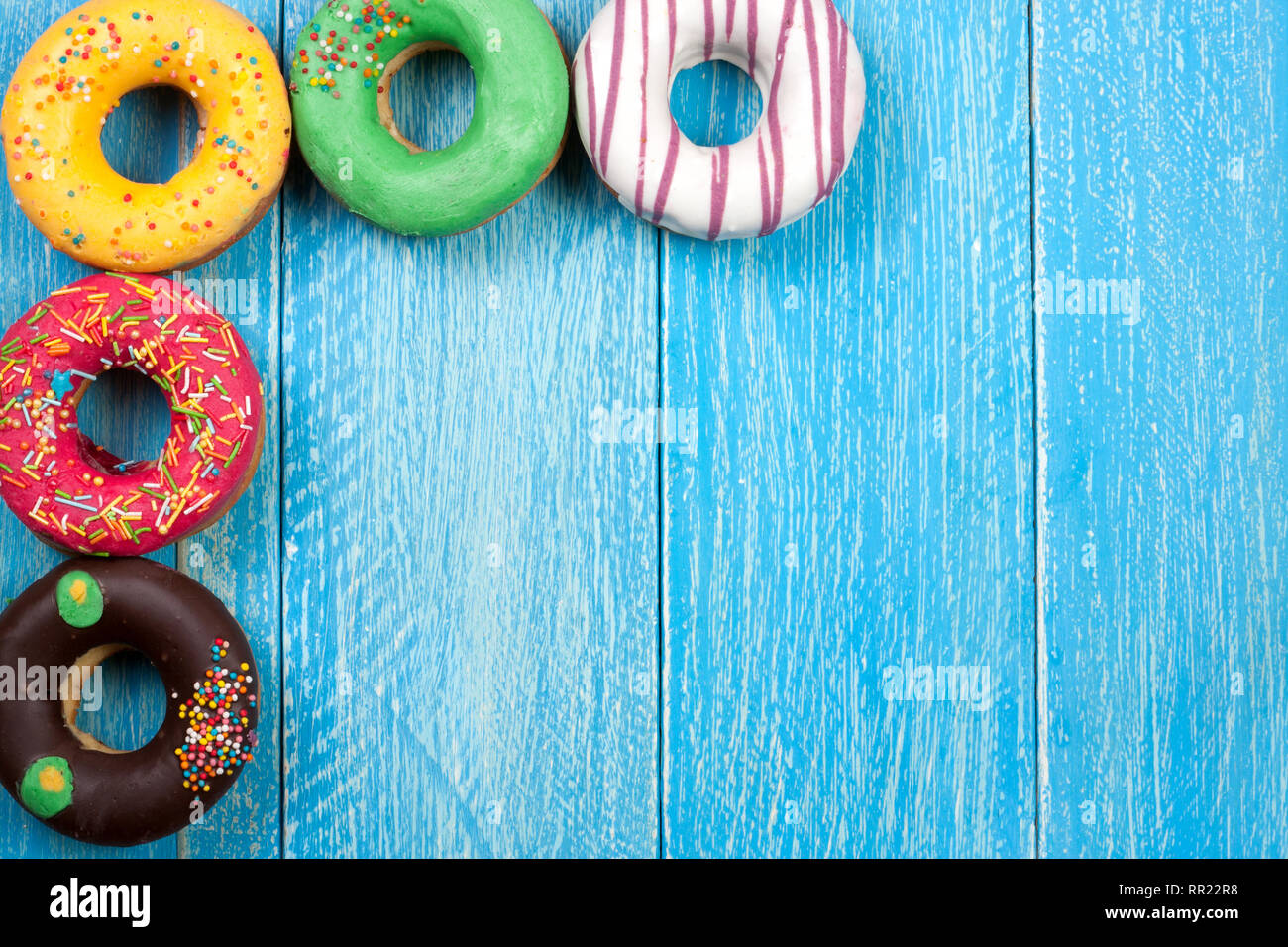 glazed donuts on a blue wooden background with copy space for your text ...