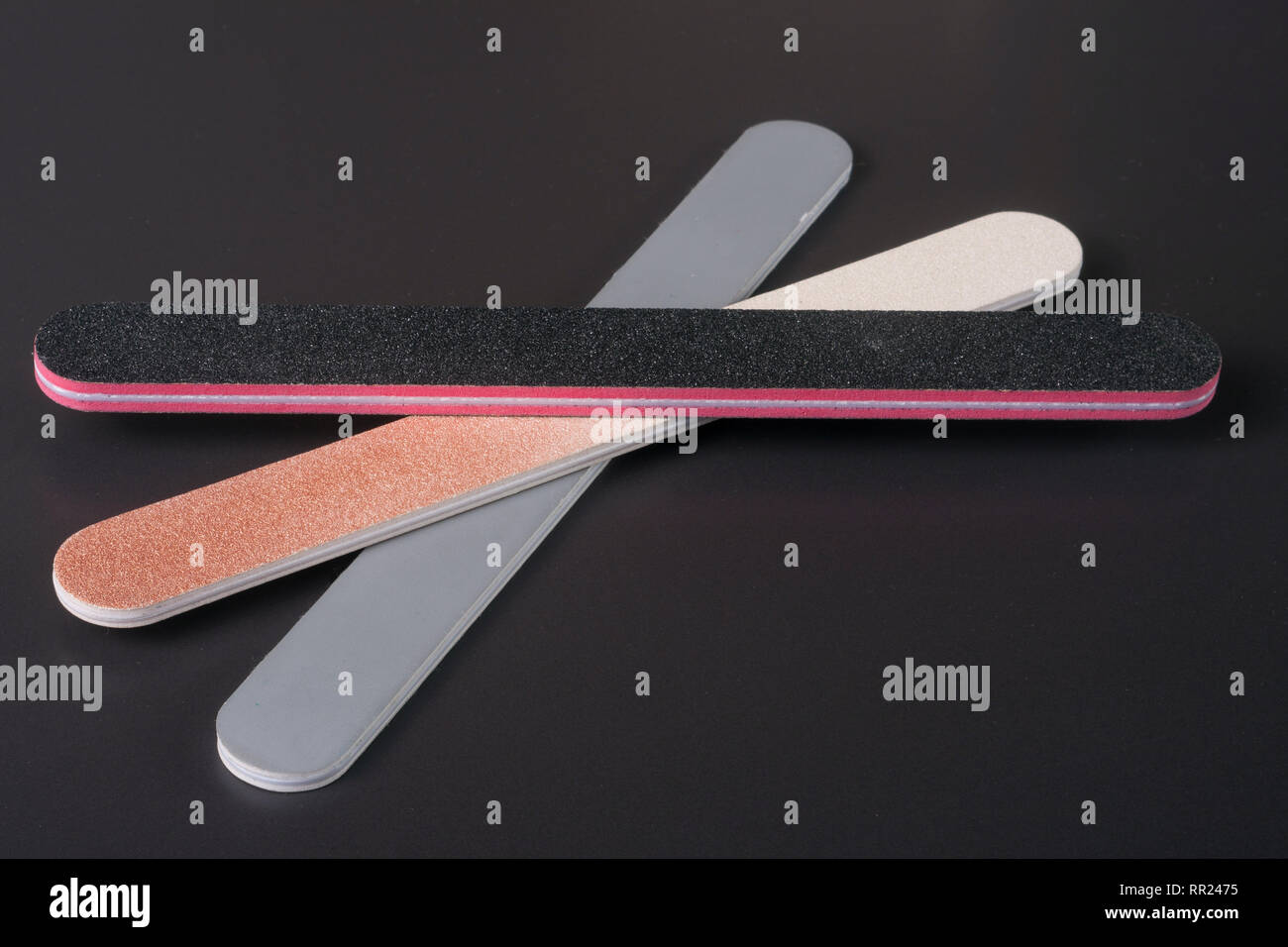Three nail file with a different abrasive on dark background Stock