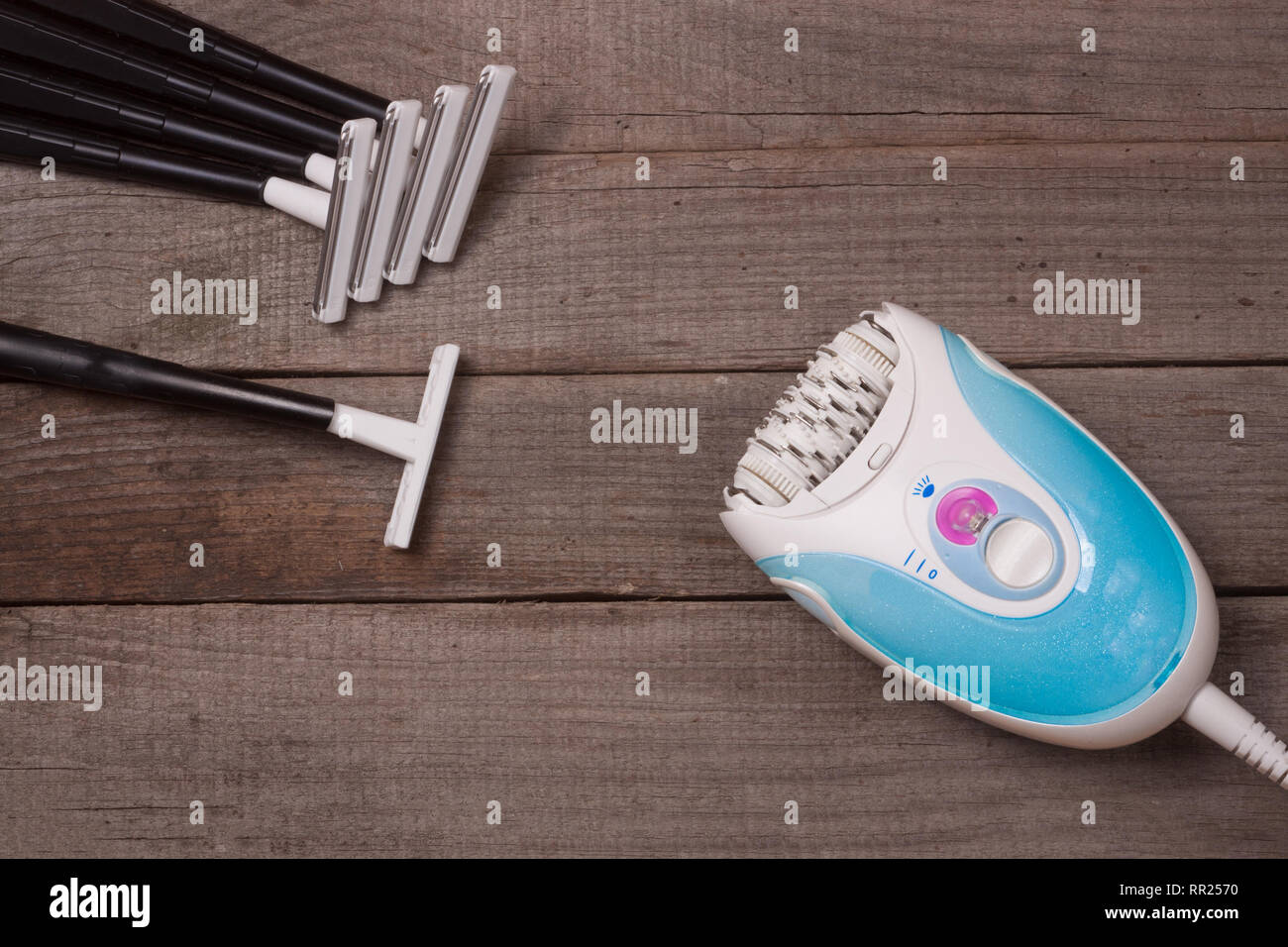 electric epilator with razor on a light wooden background Stock Photo