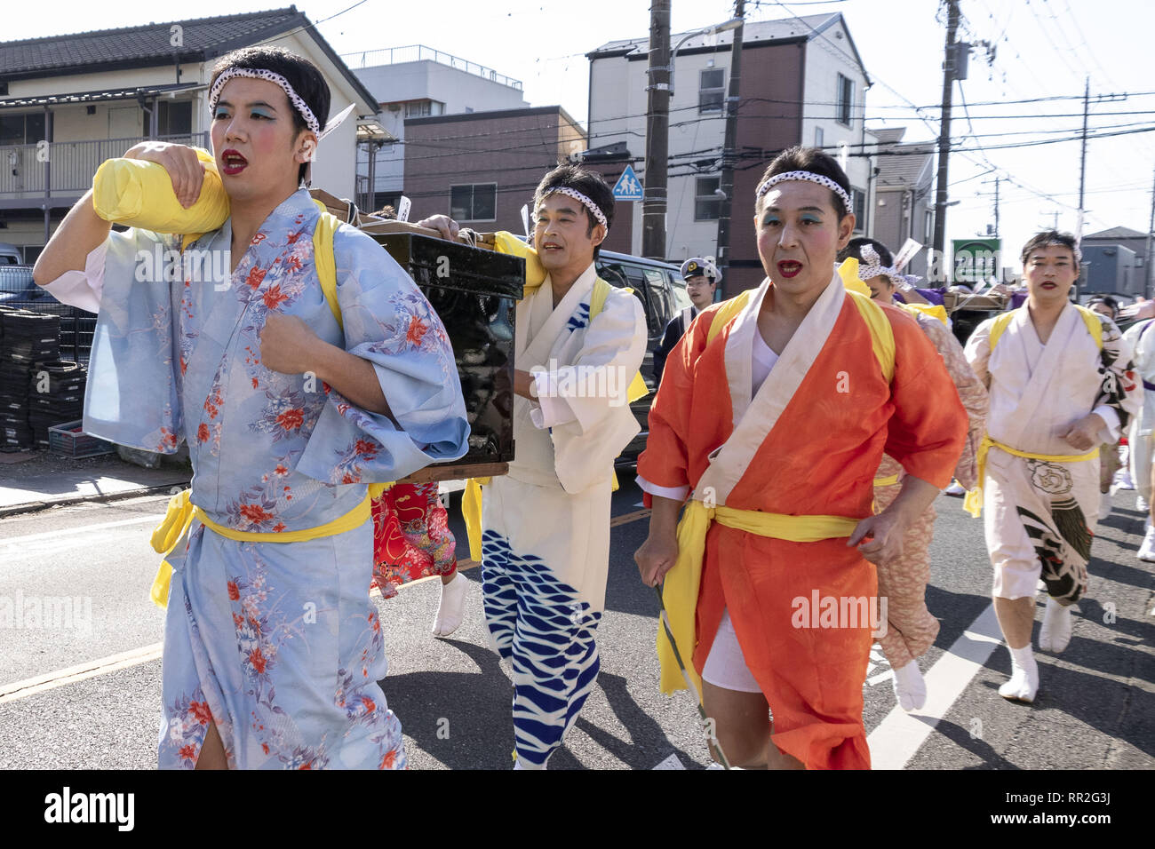 Tokyo, Japan. 24th Feb, 2019. Participants dressed in women's kimonos and  wearing makeup, run from house to house to chase away evil spirits during  the Ikazuchi no Daihannya festival. Festival volunteers carry