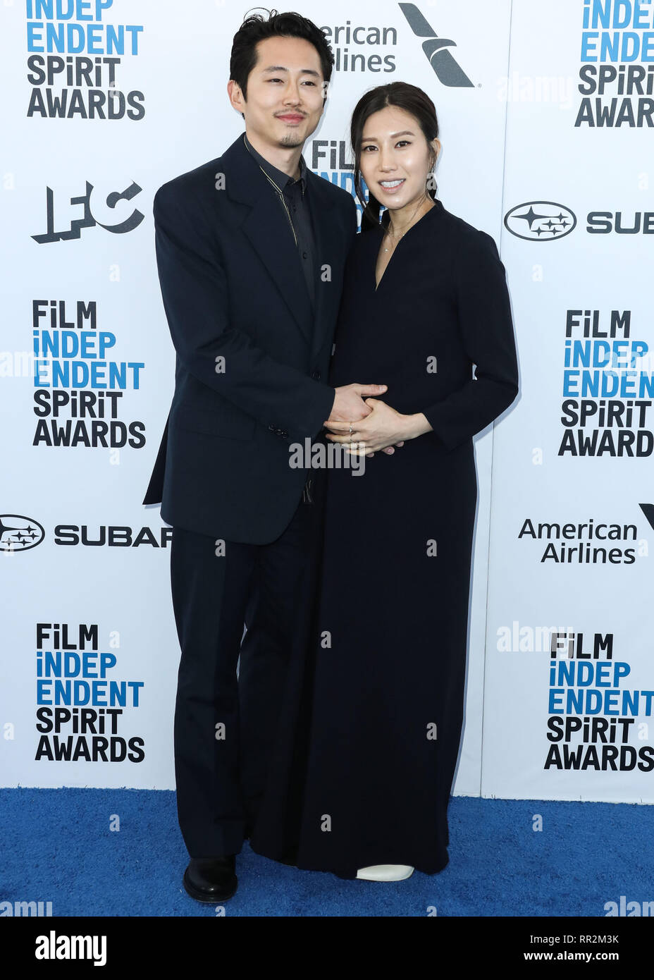 SANTA MONICA, LOS ANGELES, CA, USA - FEBRUARY 23: Actor Steven Yeun and  pregnant wife Joana Pak arrive at the 2019 Film Independent Spirit Awards  held at the Santa Monica Beach on