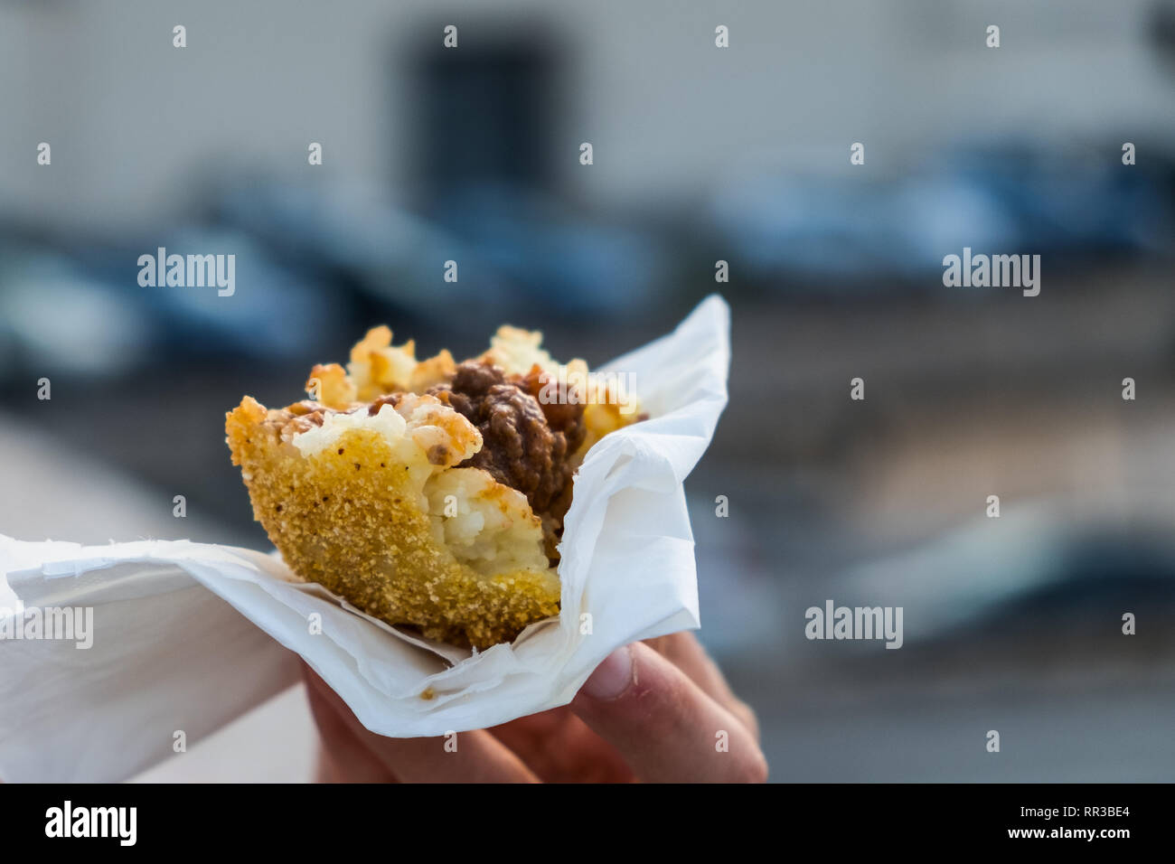 An arancino, the typical sicilian street food made of saffron rice and meat in a fried breaded ball Stock Photo