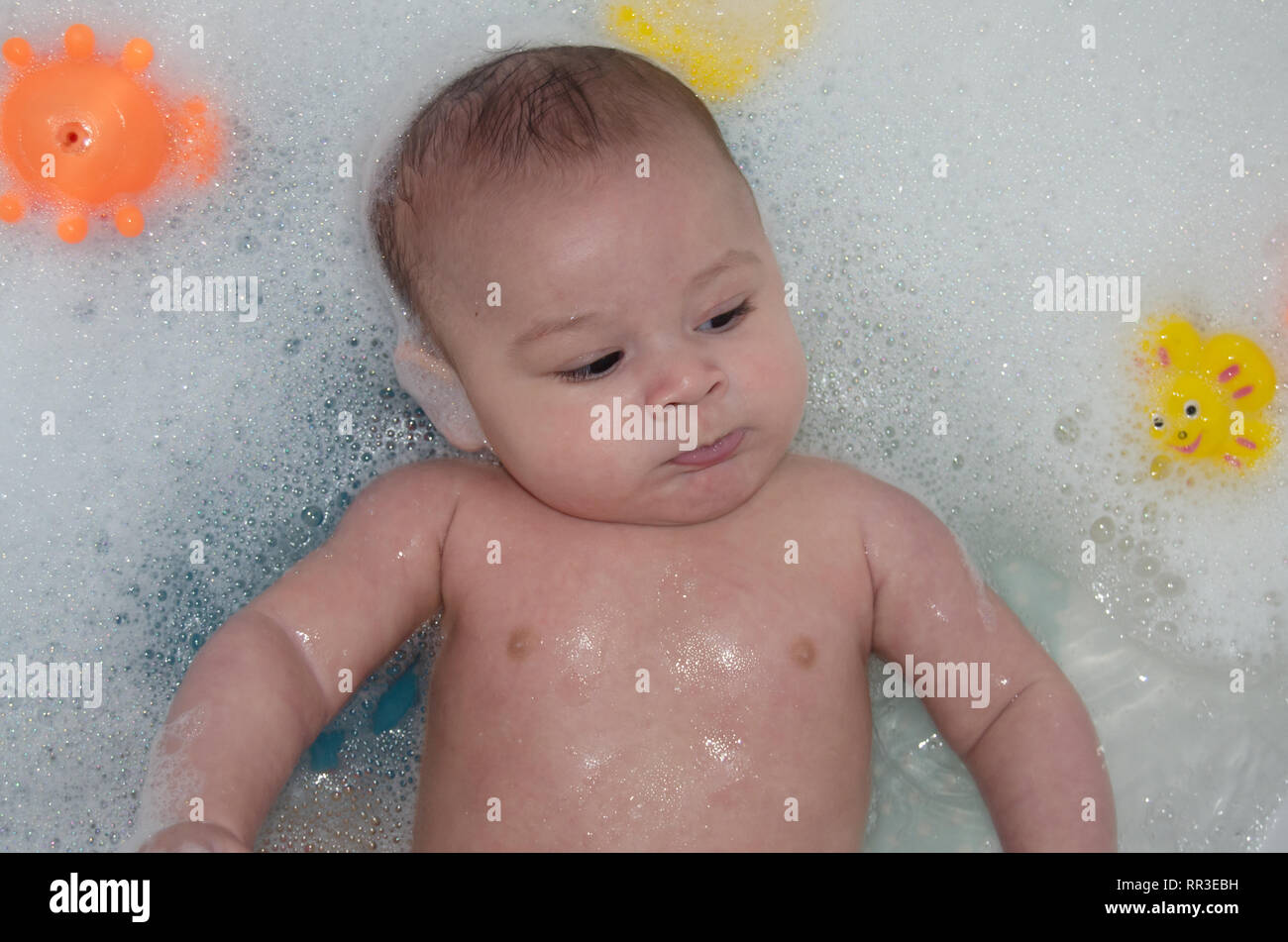 cute 4 months old baby boy having a bath with foam Hygiene an health