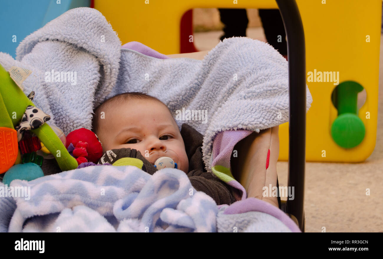 cute 3 months old baby boy making funny faces in baby carry cot outdoors Stock Photo Alamy