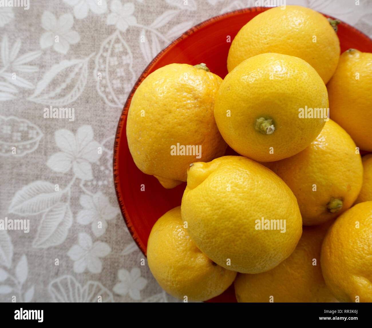 Many yellow lemons on the plate, top view. Citrus fruit with high vitamin C Stock Photo