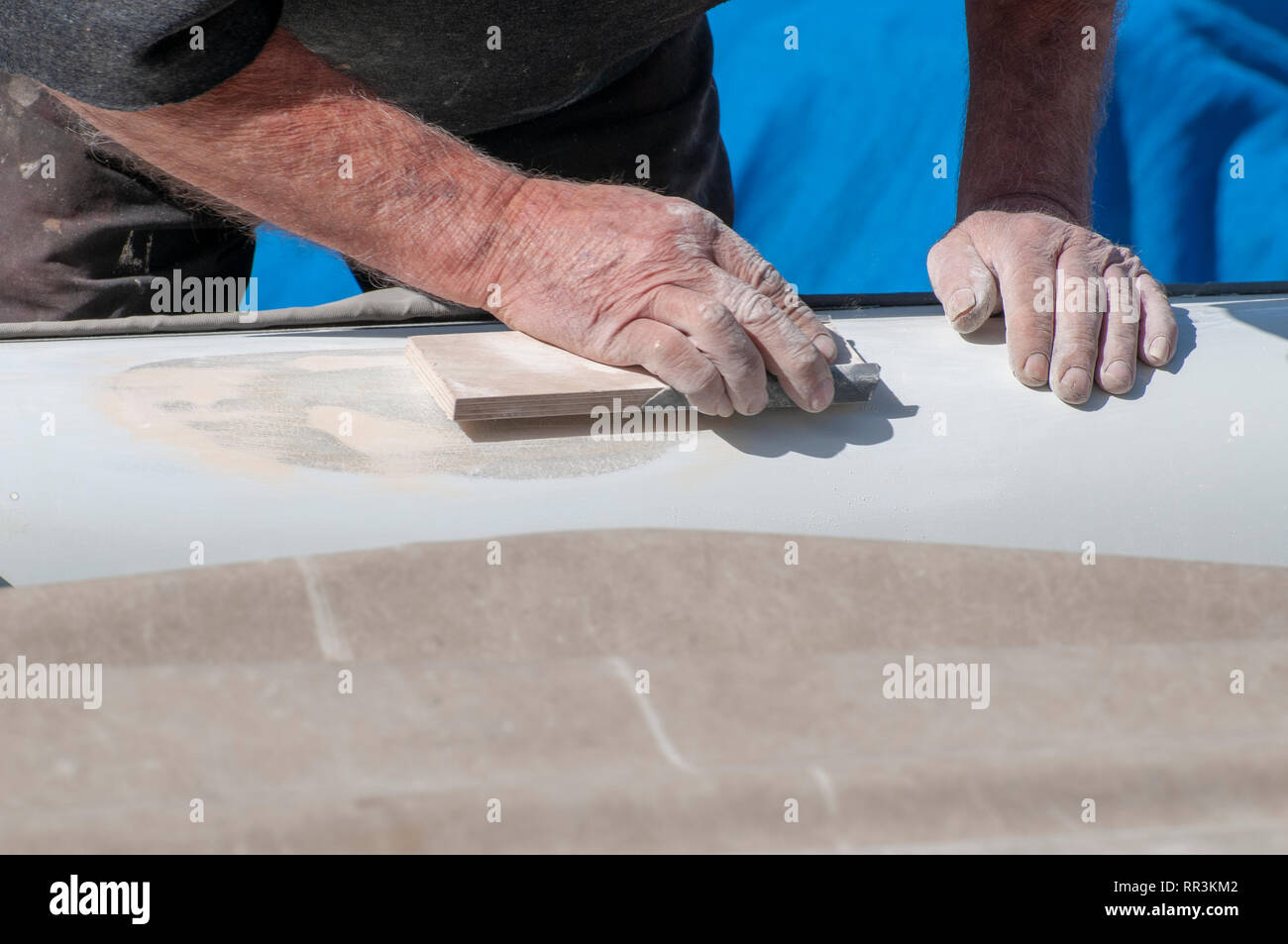 Man fixes a fiberglass boat Stock Photo