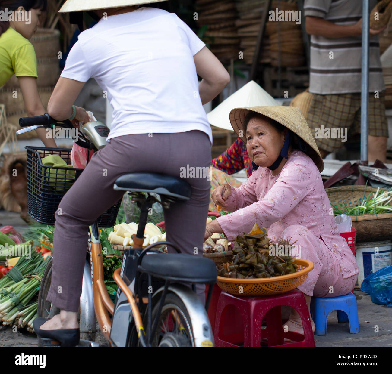 vietnamese street vendor selling vegetables on street market, Saigon, Vietnam. Stock Photo