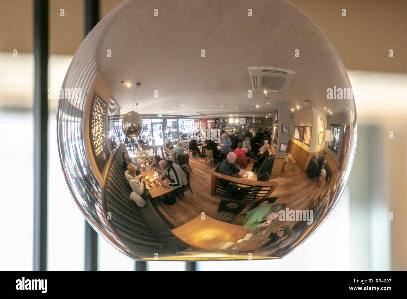 Mirrored ceiling light with cafe patrons, tables & chairs reflected, Blackpool, UK Stock Photo