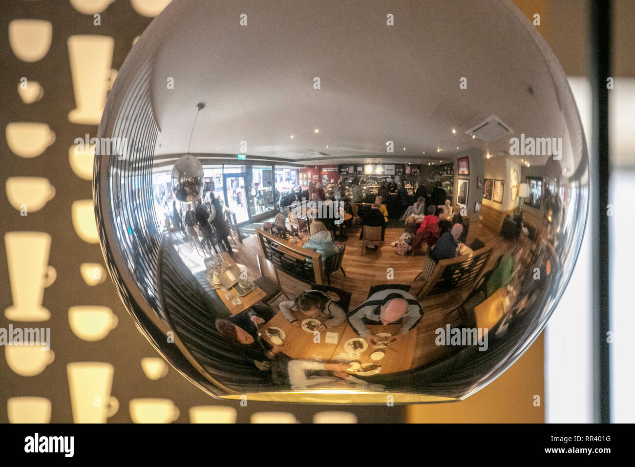 Mirrored ceiling light with cafe patrons, tables & chairs reflected, Blackpool, UK Stock Photo