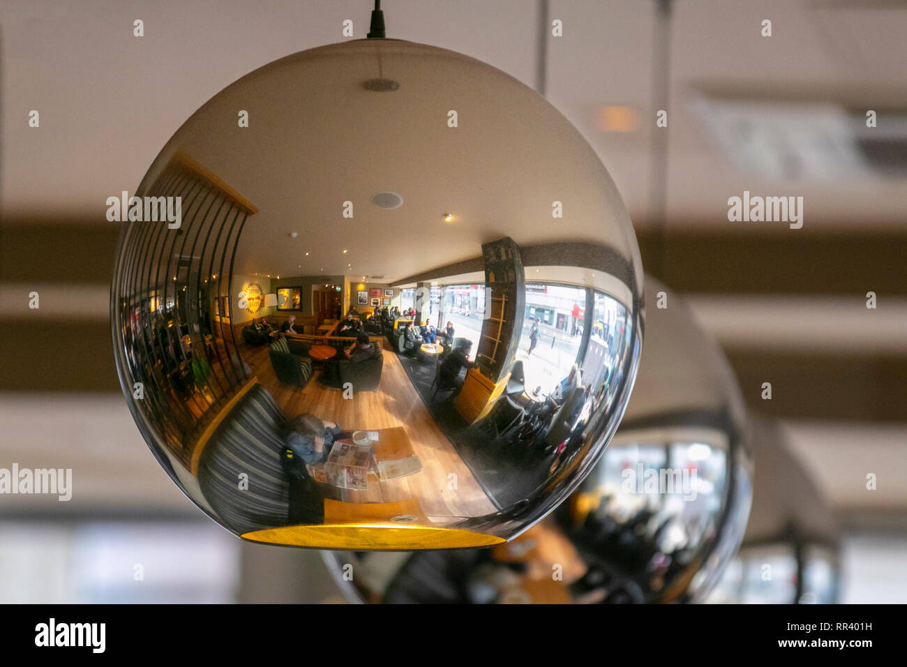 Mirrored ceiling light with cafe patrons, tables & chairs reflected, Blackpool, UK Stock Photo