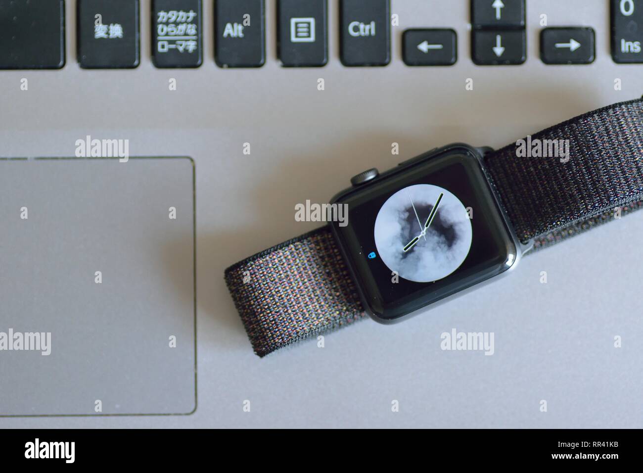 Apple Watch with blurred laptop PC keyboard background. Apple Watch is industry leader smart watch brand Stock Photo