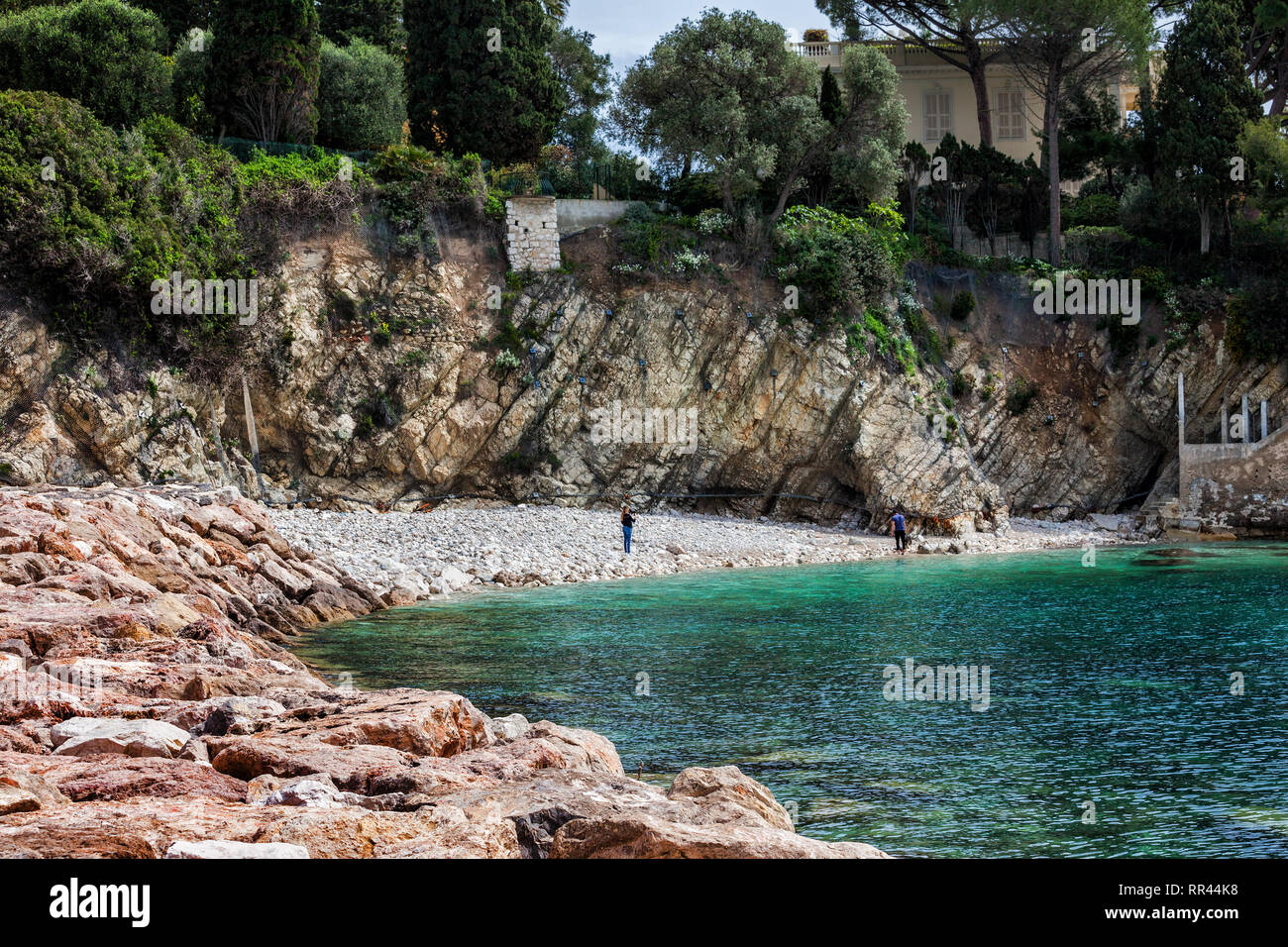 Small rocky beach below cliff and sea bay in Villefranche sur Mer on ...