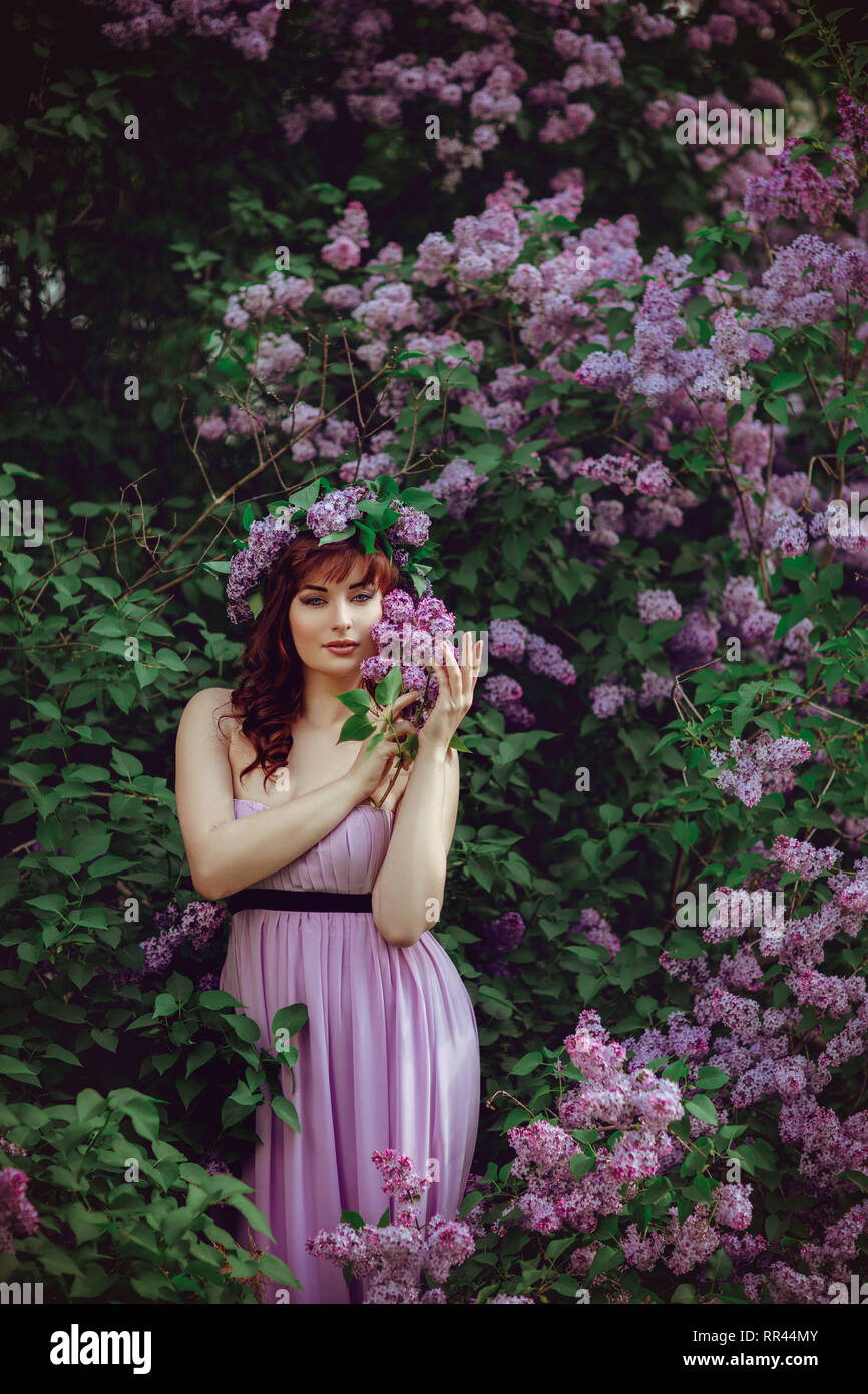beautiful young girl in purple dress with lilac flowers outdoor summer  shot. copy space Stock Photo - Alamy