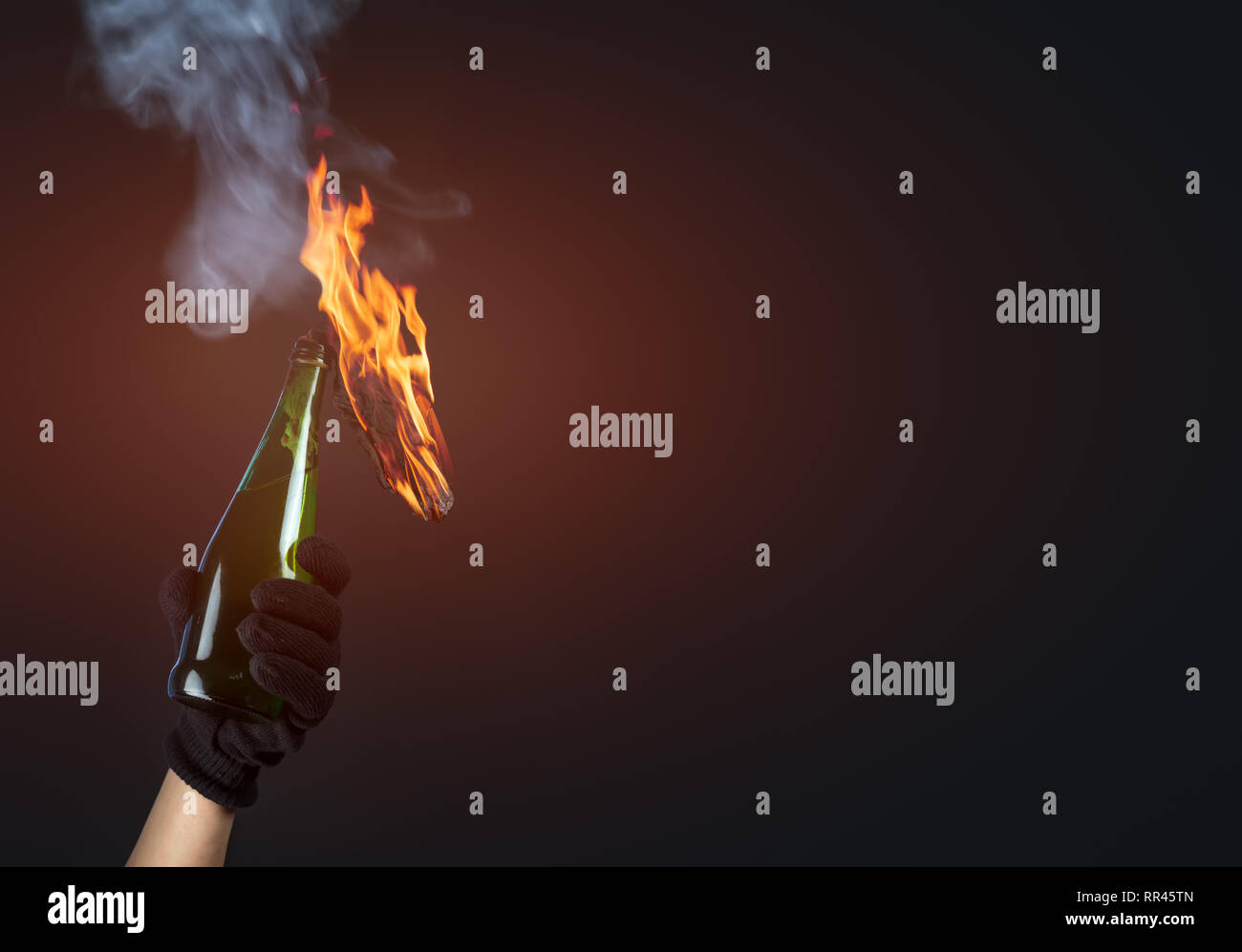 Molotov cocktail in activist hand on dark background Stock Photo