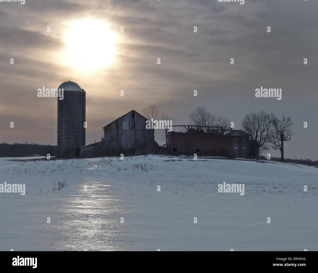 Sunrise over old, abandoned farm in winter Stock Photo