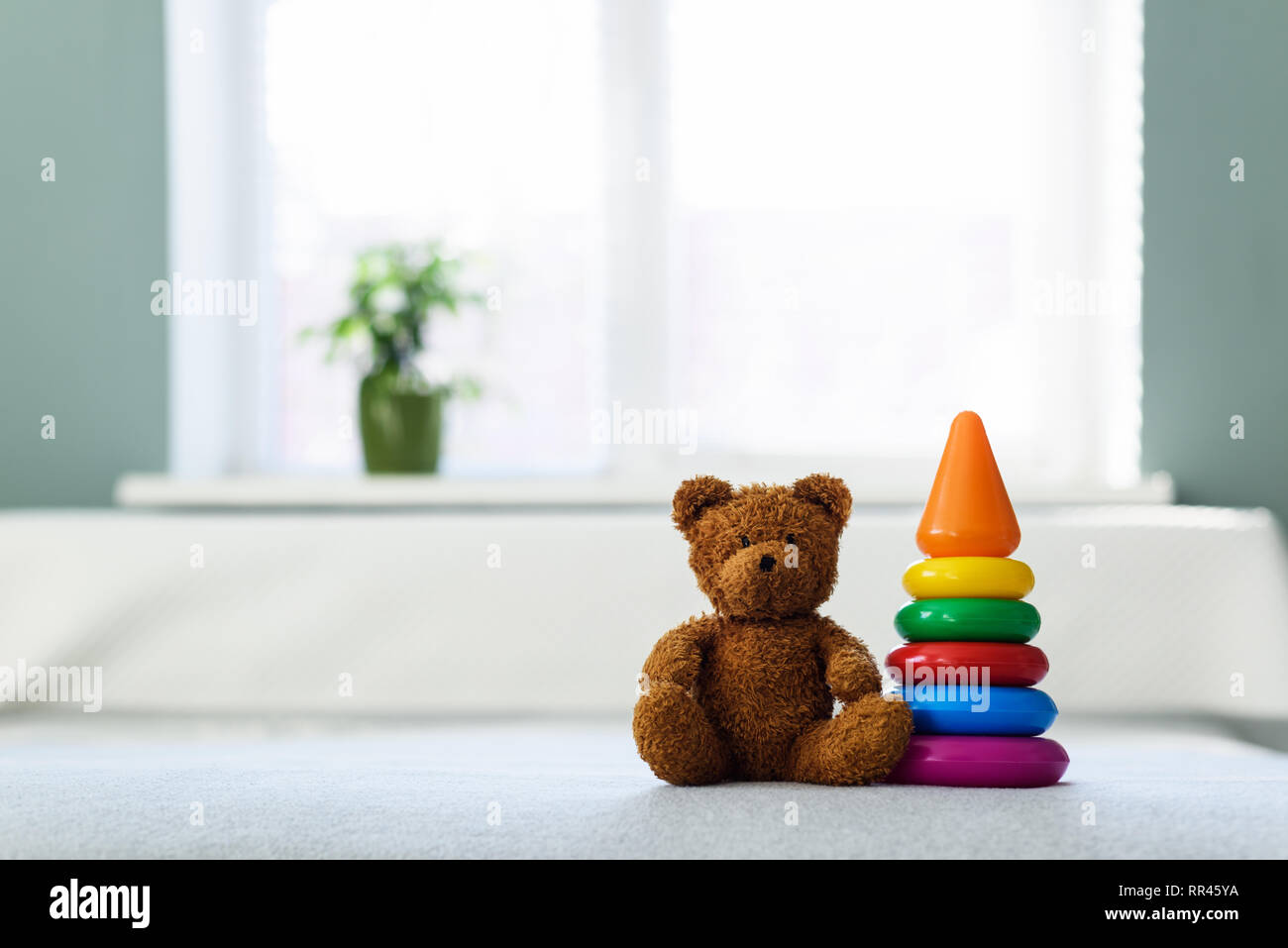 Plush teddy bear toy on white bed. Childhood concept Stock Photo