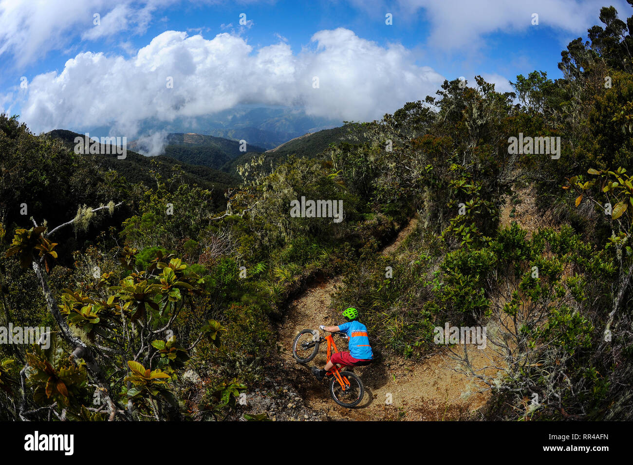 A man rides a mountain bike down a trail from the summit of Blue