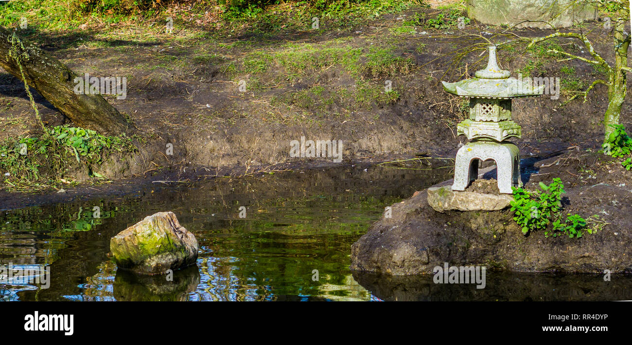 Water pond in a japanese garden with a tower sculpture, Asian garden