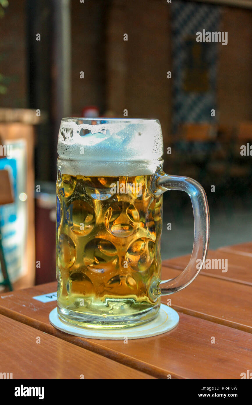 Full beer mug in Bavarian German beer garden Stock Photo Alamy