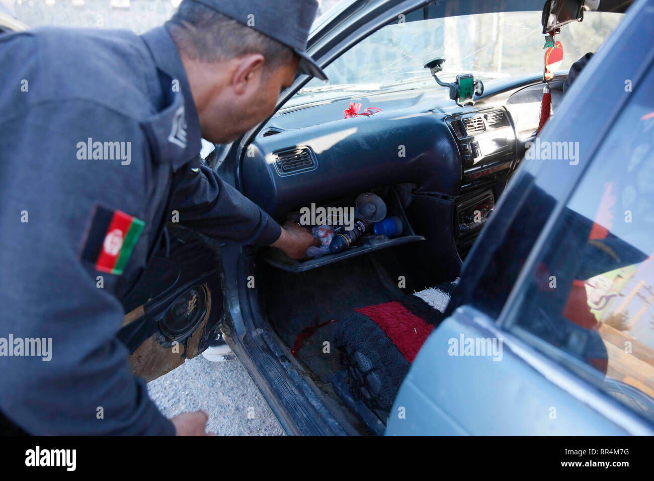 Herat, Afghanistan. 24th Feb, 2019. An Afghan policeman searches a vehicle at a security checkpoint along Herat-Farah main road in Herat, Afghanistan, Feb. 24, 2019. Afghan security forces have killed nine Taliban militants and seized nearly 900 kg narcotic drugs during separate operations, the Afghan Ministry of Interior Affairs said Saturday. In Herat province, the Afghan National Police (ANP) seized more than 570 kg of narcotics and opium and a vehicle after the ANP laid an ambush and engaged with drug traffickers along a main road. Credit: Elaha Sahel/Xinhua/Alamy Live News Stock Photo