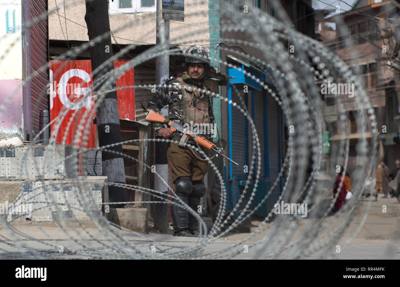 (190224) -- SRINAGAR, Feb. 24, 2019 (Xinhua) -- An Indian paramilitary trooper stands guard near a barbed wire barricade during a security lockdown in downtown area of Srinagar, the summer capital of Indian-controlled Kashmir, Feb. 24, 2019. Indian-controlled Kashmir Sunday observed a shutdown to protest arrests of political activists and move of legally abrogating a law - Article 35 A of Indian constitution - that confers special status to the region. The strike call was given by the region's separatist groups under the leadership Joint Resistance Leadership (JRL) condemning arrests and feari Stock Photo