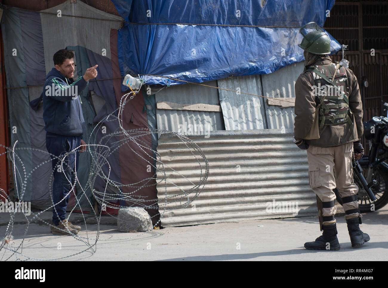 (190224) -- SRINAGAR, Feb. 24, 2019 (Xinhua) -- A Kashmiri man talks to an Indian paramilitary trooper during a security lockdown in downtown area of Srinagar, the summer capital of Indian-controlled Kashmir, Feb. 24, 2019. Indian-controlled Kashmir Sunday observed a shutdown to protest arrests of political activists and move of legally abrogating a law - Article 35 A of Indian constitution - that confers special status to the region. The strike call was given by the region's separatist groups under the leadership Joint Resistance Leadership (JRL) condemning arrests and fearing tampering with  Stock Photo