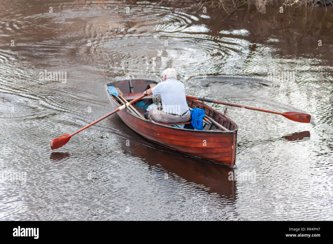 Glasgow, Scotland, UK. 24th February, 2019. UK Weather. George Parsonage from the Glasgow Humane Society rowing on a calm River Clyde on a warm, sunny afternoon. Credit: Skully/Alamy Live News Stock Photo