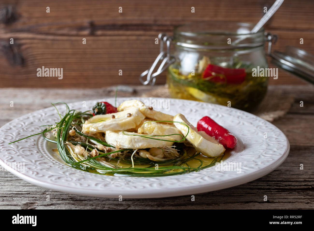 Goat cheese marinated in olive oil with wild crow garlic, hot peppers