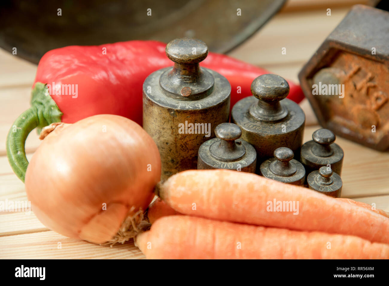 Old rusty scale weight on wooden table, Old rusty iron scale weight, vegetables Stock Photo