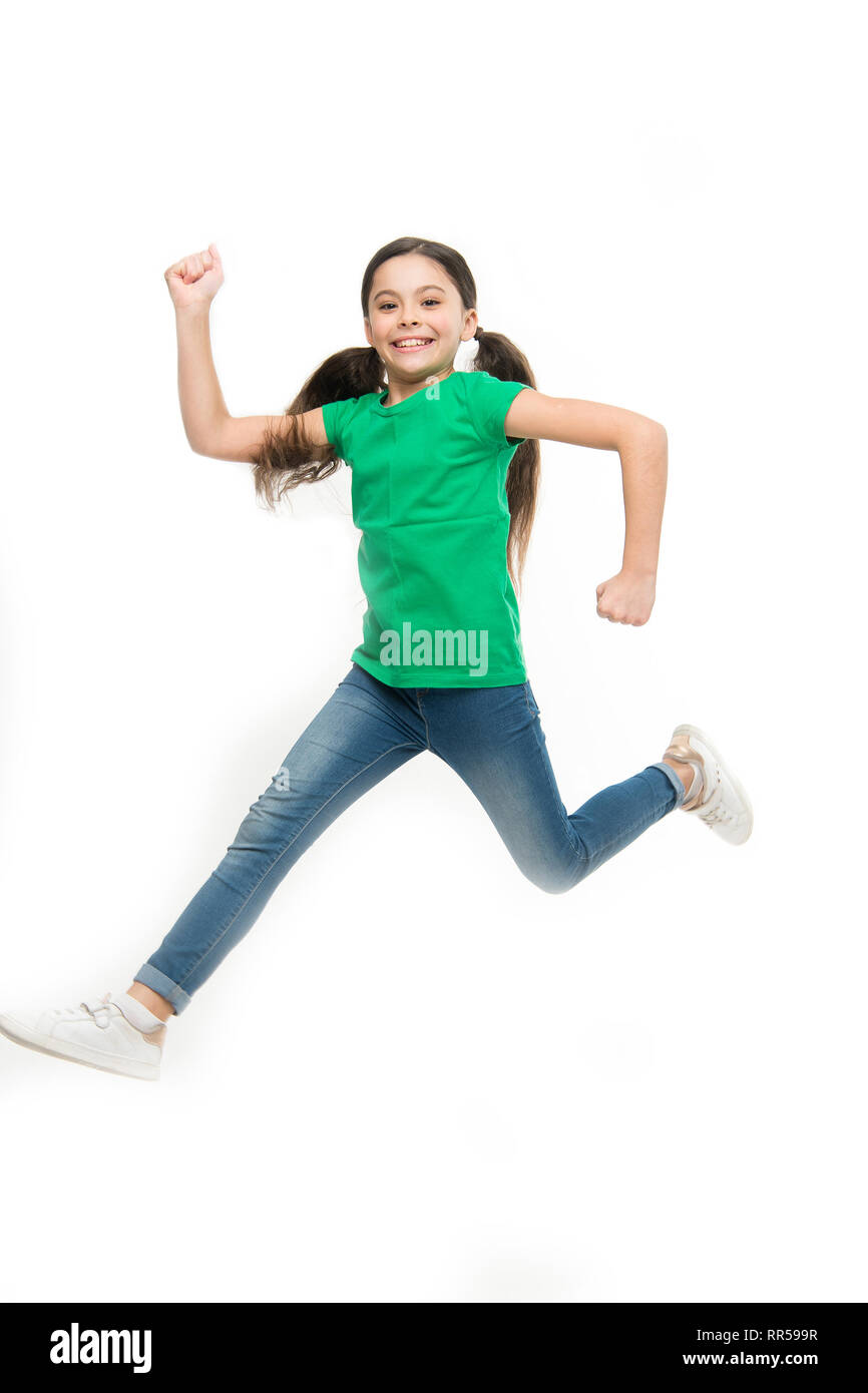 Free jumping. Adorable little girl with long brunette hair. Small child wearing casual fashion style. Small fashion model with beauty look. Little fashionista. Fashionable girl child. Fun in midair. Stock Photo