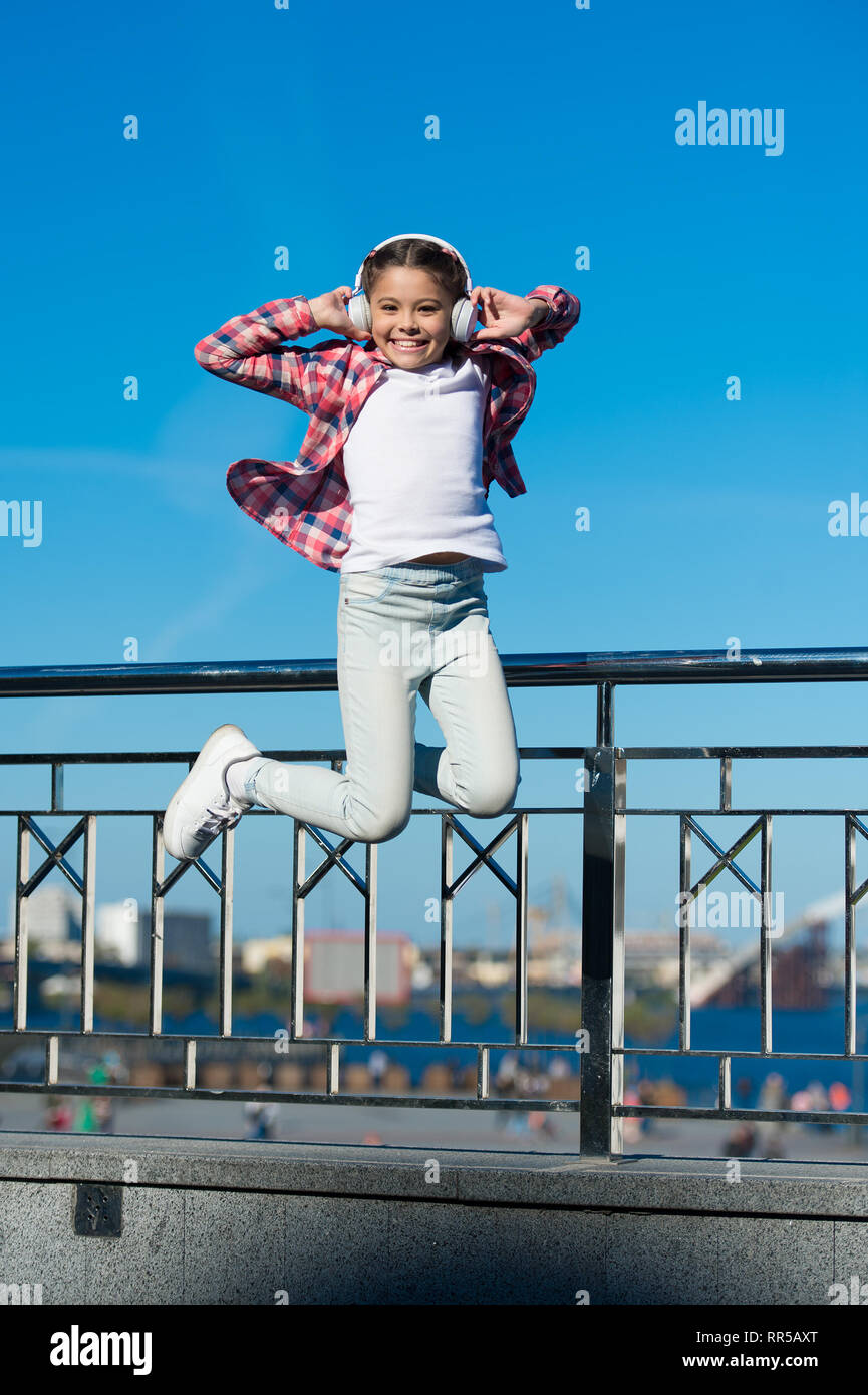 Like a rock star. Little girl jumping to music. Small happy child ...