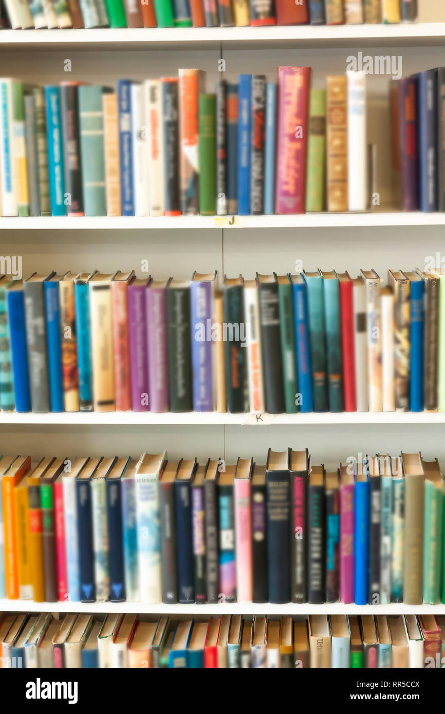 Blurred Image Of Colorful Bookshelf In Secondhand Shop Stock Photo