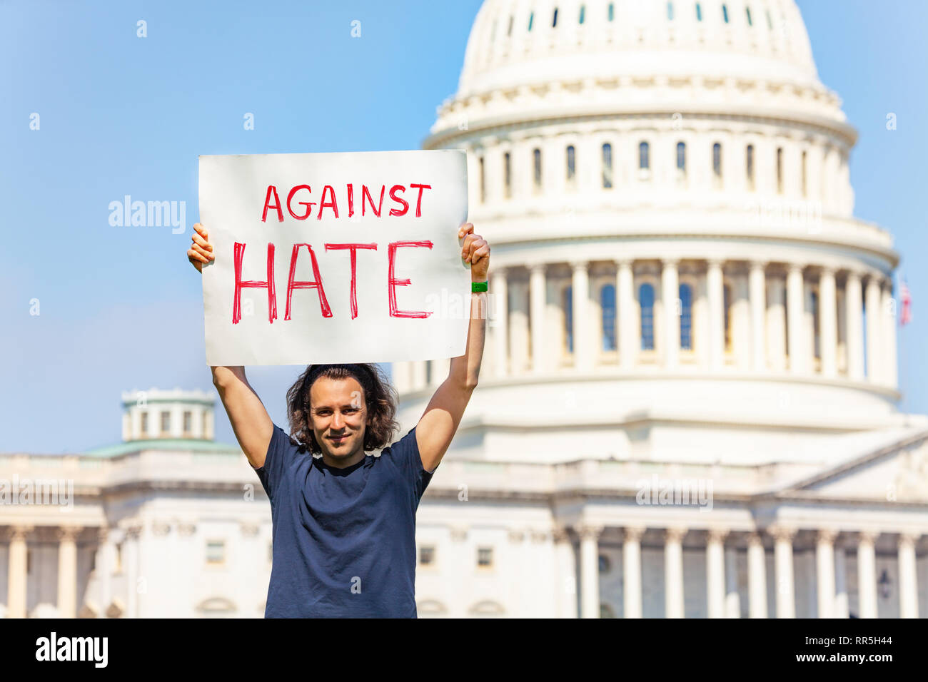 Protester holding sign against hate in his hands Stock Photo - Alamy