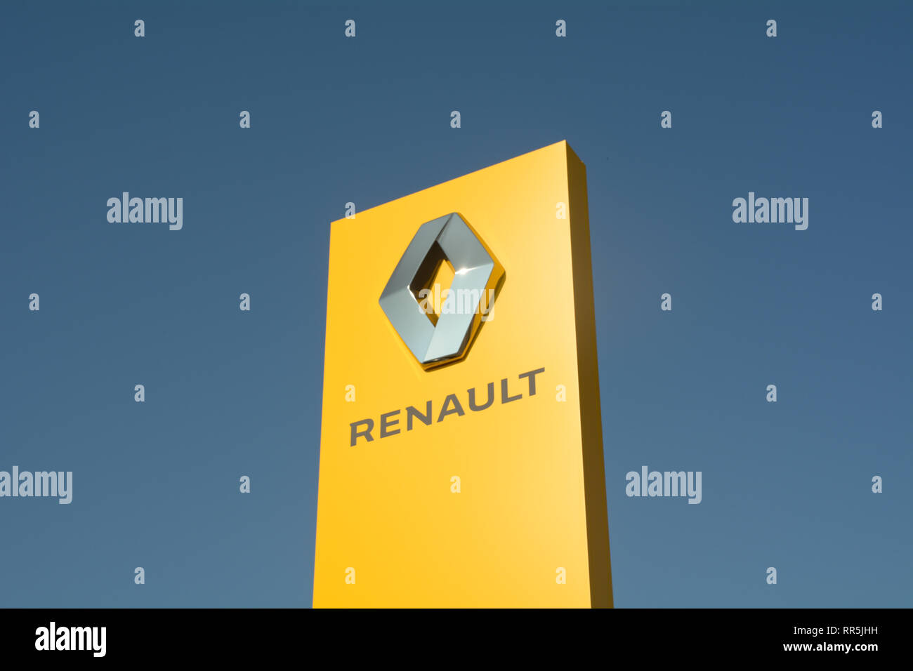 Renault car logo sign - yellow with blue sky background Stock Photo