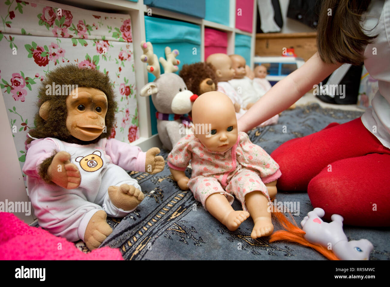 Child playing with dolls in playroom Stock Photo