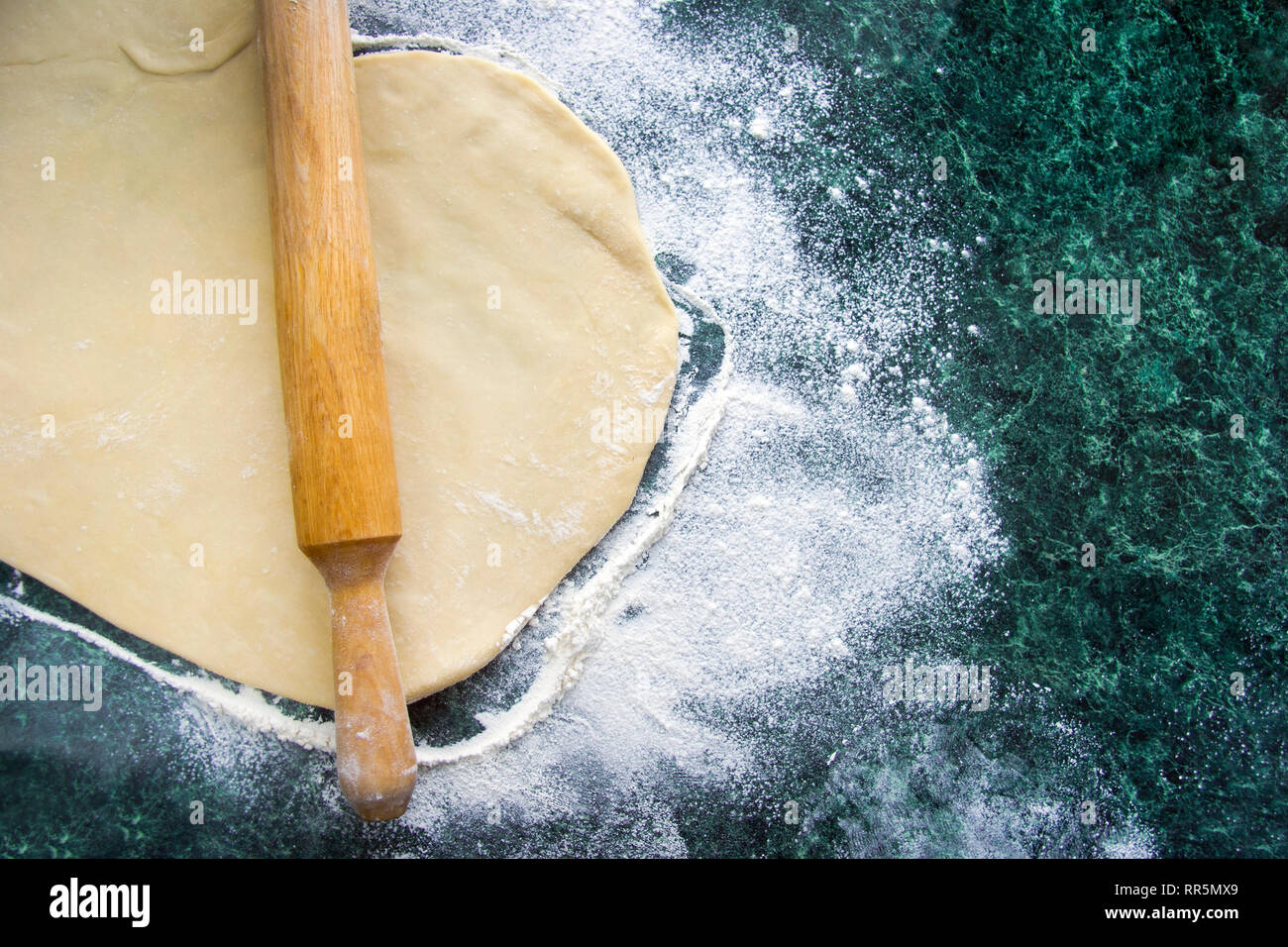 Dough for ravioli, dumplings, pizza, noodles, spaghetti, on a floured marble green table, top view Stock Photo
