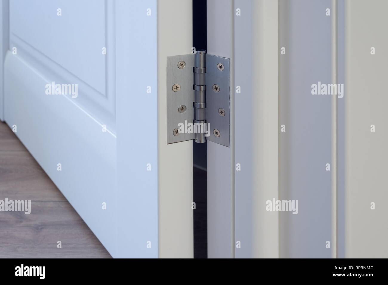 Metal chrome hinged hinges on a white interior door Stock Photo Alamy