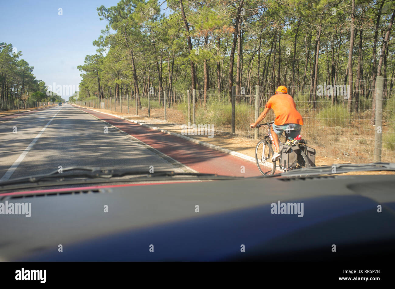 Driving carefully with senior cyclists on bike lane at country road. View from the inside of the car Stock Photo