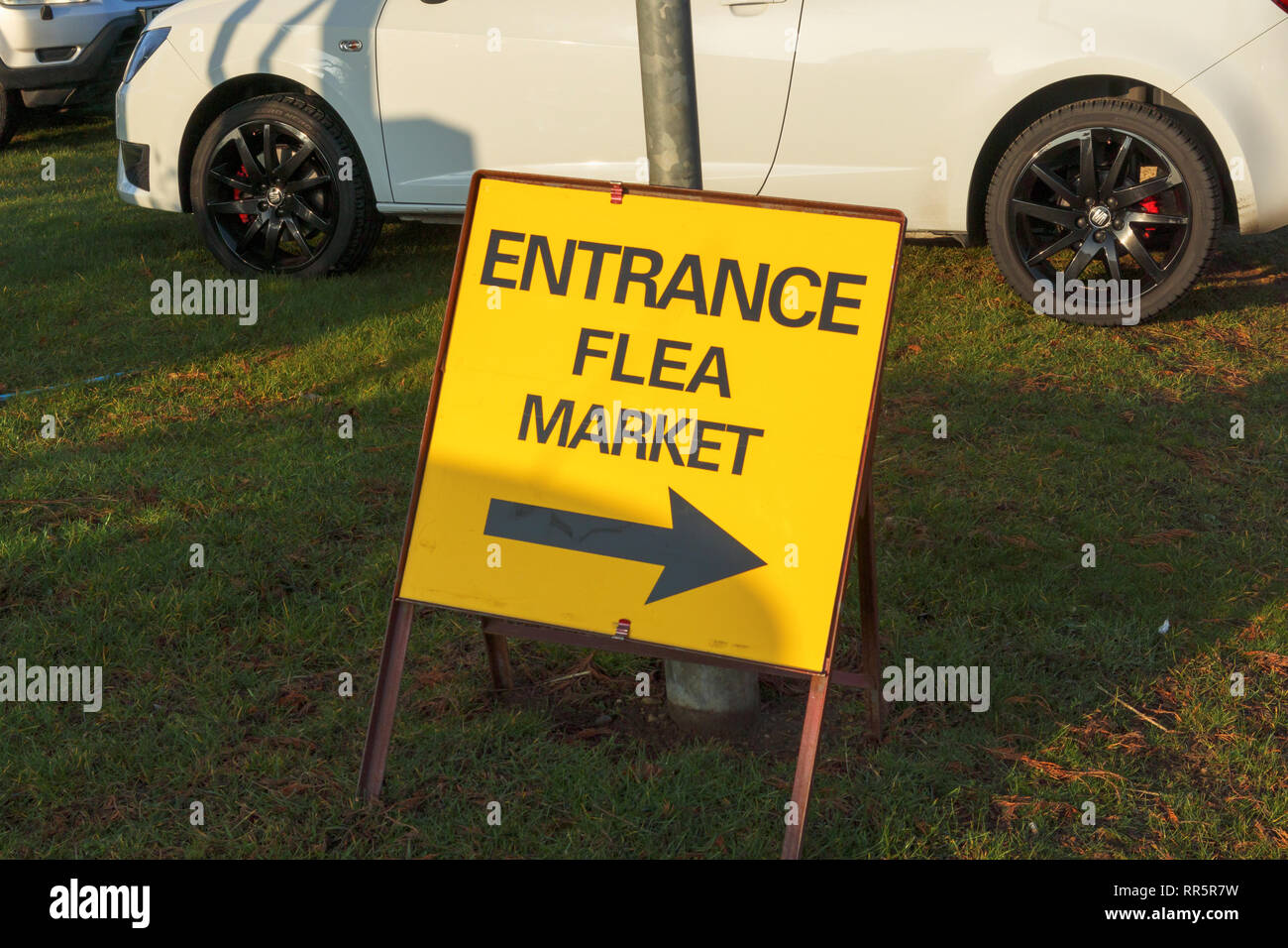 Yellow temporary entrance sign with direction arrow to a flea market event in a hall in Lincolnshire Showground, Lincoln, Lincolnshire, UK Stock Photo