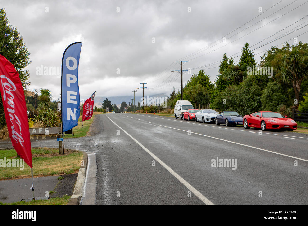 Springfield, Canterbury, New Zealand, February 24 2019: luxury cars parked along a main rural highway outside a cafe Stock Photo