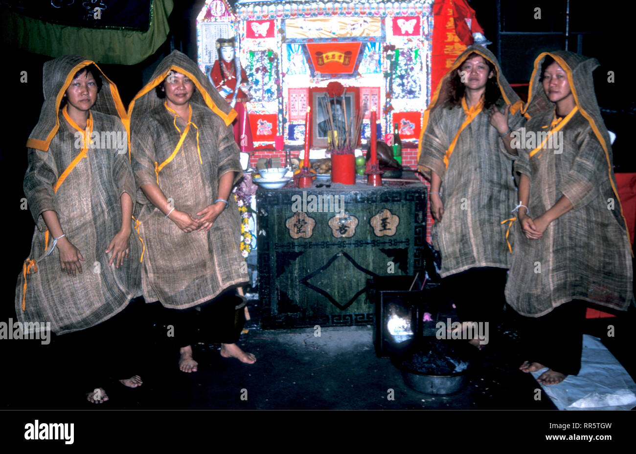 Four women wearing mourning clothes at a Chinese Taoist funeral in Malacca, Malaysia Stock Photo