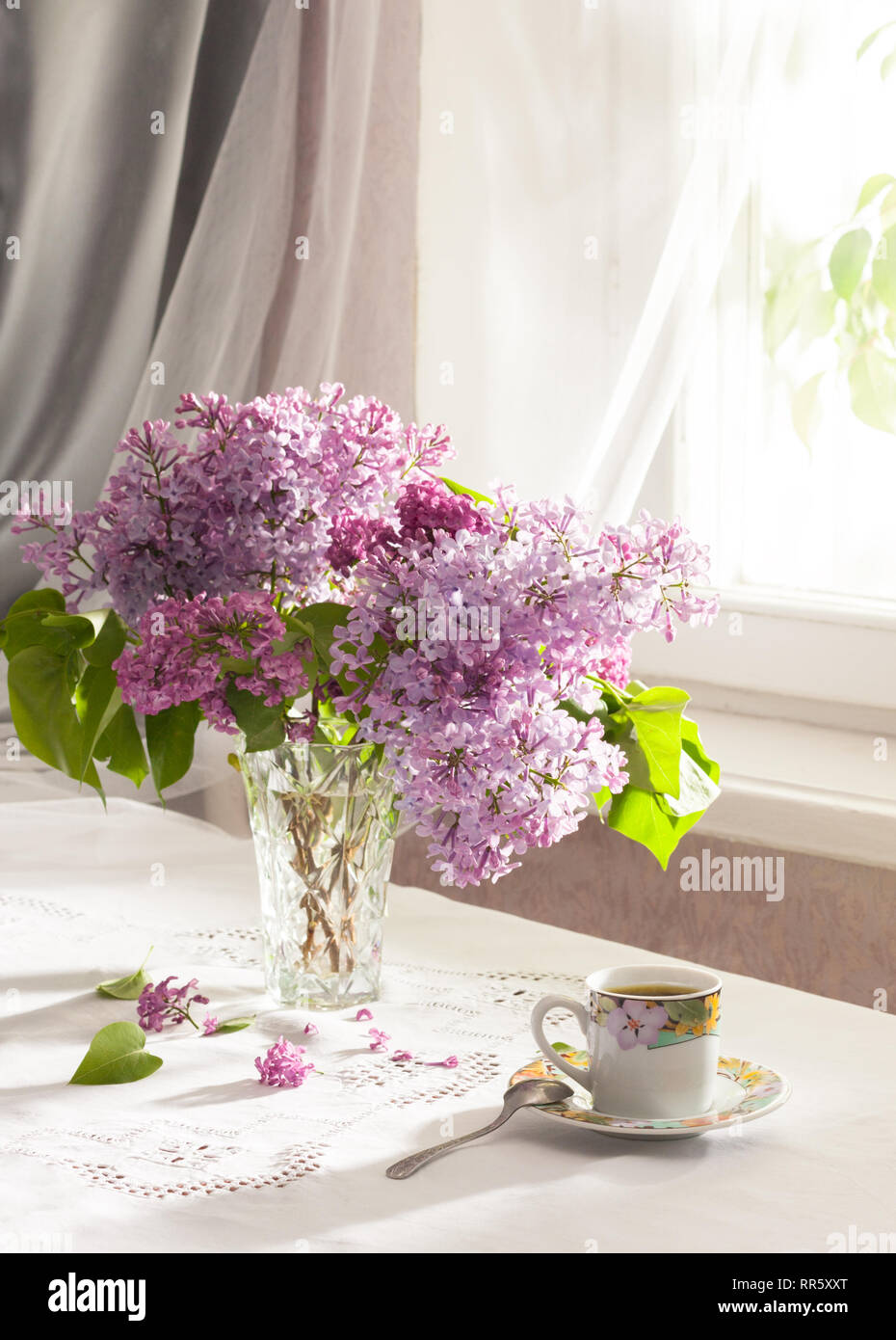 Retro still life with a bouquet of lilac and cup of coffee. Soft focus ...