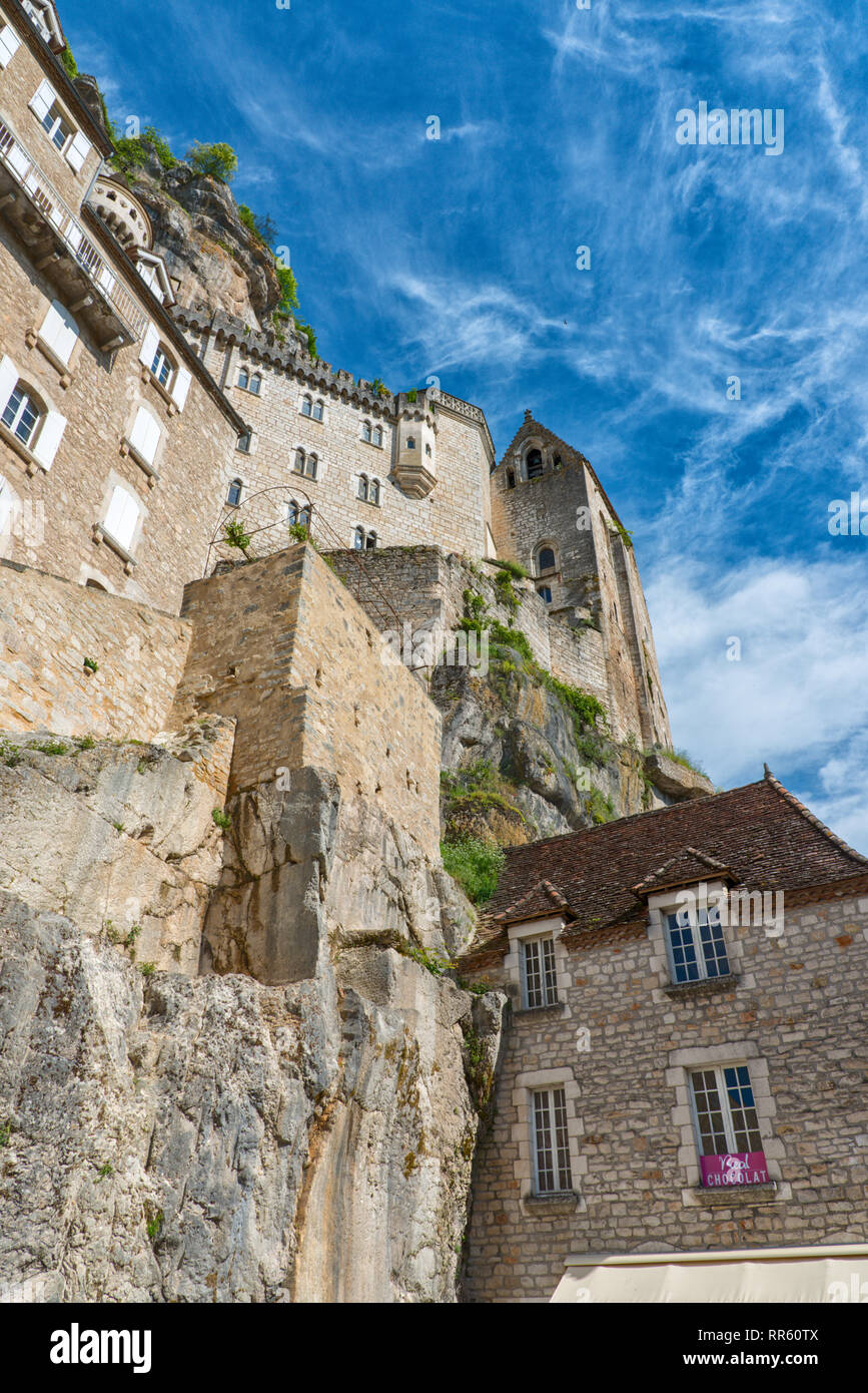 A view of the Rocamadour cliff face looking up from the main street.  Hiuses and a church can be seen clinging to the cliff face. Stock Photo
