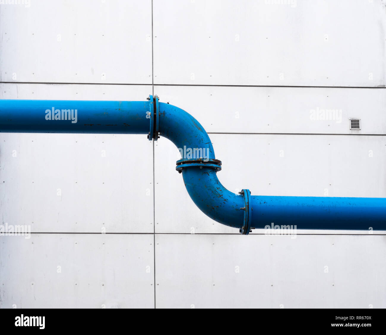 A water pipeline across the city in front of a plain facade Stock Photo