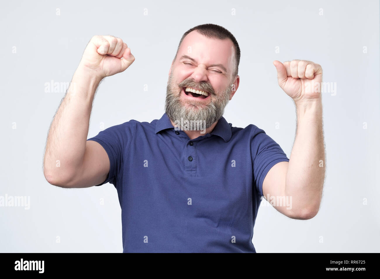 Successful emotional mature man screaming Yes and raising clenched