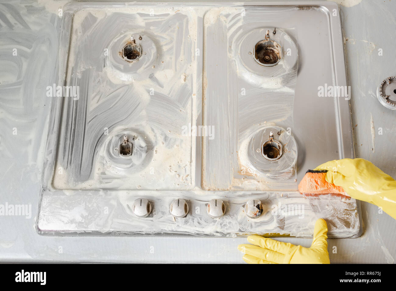 Hands in yellow rubber gloves wash with soap kitchen cooking equipment. Top view. Stock Photo